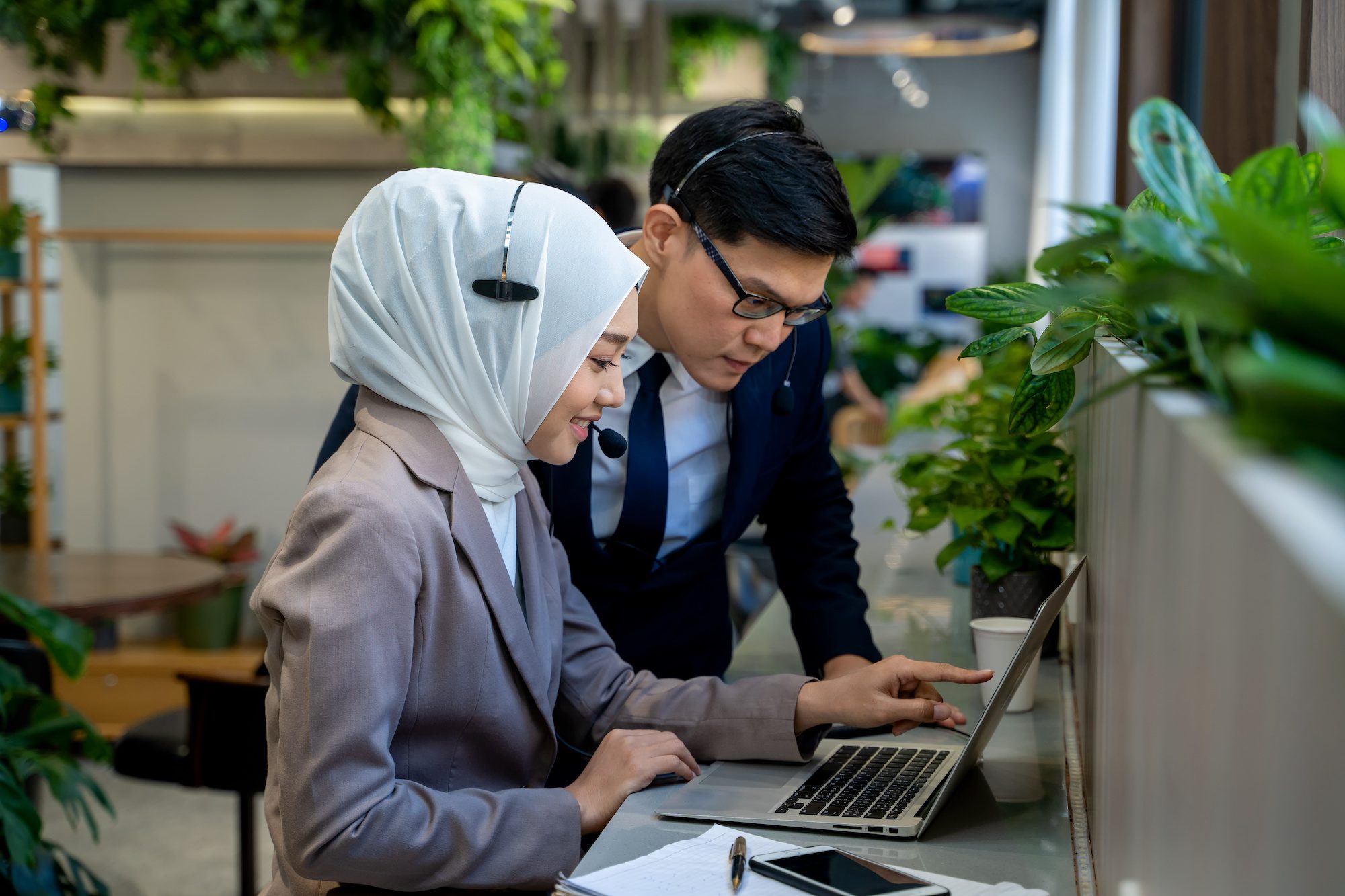 Businessman and Muslim lady employee with headset use laptop working in office.Work concept of diversity of culture different race type of people co-working together 3 On-Site Interpreters